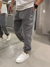 Pantalón de jogging con efecto lavado, corte holgado y puños elásticos en los tobillos. Cuenta con bolsillos laterales y cintura elástica.