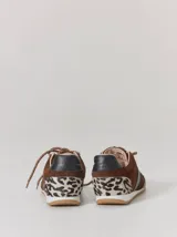 Championes de cuero con diseño combinado en color marrón y negro. Presentan una estructura de gamuza marrón con refuerzos de cuero liso negro en la puntera y laterales, cordones bicolores y suela de goma.
