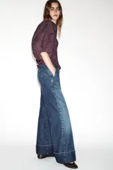Jeans de tiro bajo con pernera recta y bajo con vuelta. Cuenta con cinco bolsillos y cierre frontal con cremallera y botones.