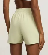 Bermuda deportiva verde claro de modal, con cintura elástica y frisos contrastantes en los laterales.