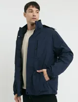 Campera 2 en 1 azul marino con capucha desmontable, cierre frontal con solapa de botones a presión y bolsillos laterales con cierre.
