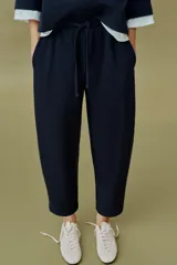 Pantalón balloon de algodón color crudo, con tiro medio, cintura elástica ajustable con cordón y bolsillos laterales.