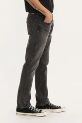 Pantalón de jean corte slim fit, color gris oscuro con efecto lavado, de tiro medio y cierre frontal con botón y cremallera.