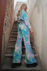 Pantalón palazzo de crepe de seda estampado con motivos florales en tonos verde, celeste, blanco y lavanda. Tiene cierre invisible lateral y costura francesa.