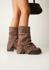 Botas de cuero negro con caña media, suela track y hebillas decorativas.