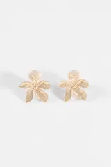 Caravanas metálicas con diseño de flor de cinco pétalos con textura estriada y cierre tipo clip.