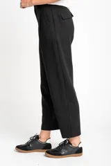 Pantalón negro de algodón peinado, corte recto y tiro medio, con pinzas delanteras y bolsillos laterales.