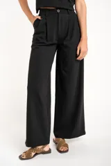 Pantalón negro de vestir, de corte wide leg y tiro medio.