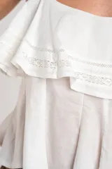 Top negro de 100% algodón, con tirantes finos, escote recto y volados dobles con detalles de encaje en el frente.