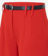 Short sastrero rojo de talle alto, con pinzas delanteras, cierre oculto y bolsillos traseros. Incluye un cinturón delgado de poliuretano.