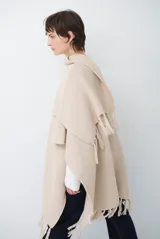 Ruana de tejido de punto en color negro, con diseño de cuello alto y terminaciones con flecos en los bordes.