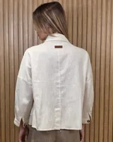 Sobrecamisa de lino color beige, con cuello camisero, cierre frontal de botones carey, mangas largas y bolsillos frontales con solapa.
