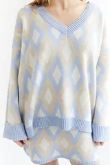 Sweater oversize con cuello en V y estampado de rombos en tonos lila, rosa y rojo. Tejido de lana artesanal.