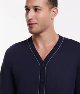 Pijama masculino de dos piezas en color azul marino. Incluye una camisa de manga larga con cuello en V, cierre frontal abotonado y detalles de costuras en contraste, junto con un pantalón de corte recto y cintura elástica.