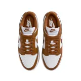 Championes Nike Dunk Low con diseño bicolor en blanco y marrón. Presentan una silueta clásica de perfil bajo con paneles de cuero, cierre de cordones y suela de goma resistente.