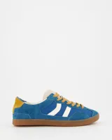 Championes Coolway modelo Kizuna, de estilo retro con diseño en azul y blanco. Confeccionados en una combinación de ante y nylon, presentan cordones en tono mostaza, talón en contraste y suela de goma color miel con costura reforzada.