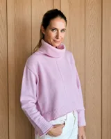 Polerón de lana lambswool color rosado, con cuello alto tipo tortuga, mangas largas y diseño holgado con ruedo acanalado.