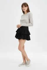 Minifalda negra de viscosa con diseño de volados escalonados.