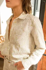 Camisa de lino con estampado floral liberty, cuello clásico, cierre frontal con botones y detalle de aplique bordado en encaje sobre el pecho.
