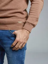 Remera tejida gris con cuello alto y medio cierre.