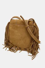 Bolso tipo bandolera confeccionado en serraje color marrón, con diseño de flecos en el contorno y detalle de tachas metálicas formando flores en la solapa. Cuenta con asa larga regulable, cierre imantado y bolsillo interior.