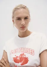 Camiseta blanca de algodón con cuello redondo, manga corta y diseño estampado en color rojo en la parte frontal.
