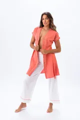 Vestido camisero color salmón con botones frontales y ribete blanco en cuello, mangas y abertura. Pantalón palazzo blanco con ribete salmón en el ruedo.