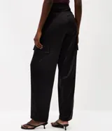 Pantalón cargo de tricolina color negro, de corte recto y holgado, con bolsillos laterales utilitarios.
