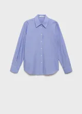 Camisa de corte recto con diseño de rayas verticales, cuello camisero clásico y cierre frontal con botones. Presenta mangas largas con puños abotonados.