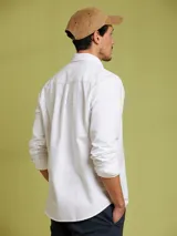 Camisa de corte regular fit, confeccionada en tejido oxford de algodón. Presenta cuello clásico, cierre frontal con botones y un bolsillo en el pecho.