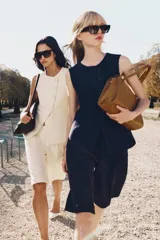 Bolso de hombro de piel color tostado, con detalle de costuras verticales pespunteadas en el cuerpo, doble asa de hombro y cierre con botones imantados.