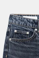 Jeans de tiro alto con corte mom fit, cinco bolsillos y cierre frontal con cremallera y botón metálico.