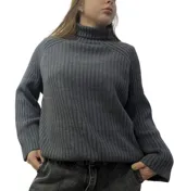 Sweater gris de tejido de punto acanalado, con cuello alto y mangas largas.