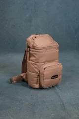 Mochila matera de diseño vertical, color gris azulado, con acabado acolchado y cierres frontales. Cuenta con un compartimento principal espacioso, un bolsillo frontal externo y un asa superior para transporte manual.