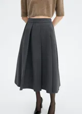 Falda midi gris con pliegues anchos en la parte delantera y corte acampanado.