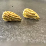 Par de aros dorados con forma de gota y textura acanalada horizontalmente. Fabricados en plata 925 con acabado en oro de 18k.