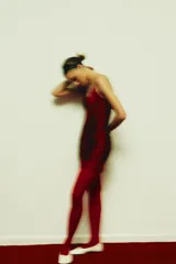 Vestido corto color rojo oscuro (vino) con escote en V pronunciado y tirantes finos. Presenta un diseño con flecos o tiras superpuestas que caen verticalmente y terminación en encaje festoneado en el ruedo y el escote.