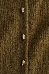 Saco de punto acanalado con cuello redondo, cierre frontal con botones metálicos y diseño entallado con peplum en la cintura.