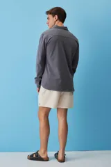 Buzo de friza de algodón color gris oscuro, con cuello polo y cierre frontal de botones, de manga larga y calce relajado.