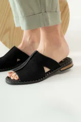 Sandalias negras de gamuza con puntera descubierta y detalle de tachas plateadas en la suela.