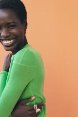 Jersey de punto fino con diseño color block en tonos rojo, bordó y blanco. Presenta cuello redondo y manga larga.