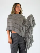 Pashmina de punto color crudo, con diseño calado de rayas verticales y flecos largos en los bordes.