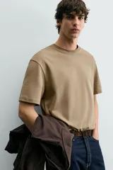 Camiseta de corte relajado con cuello redondo y manga corta, confeccionada en tejido de algodón liso.