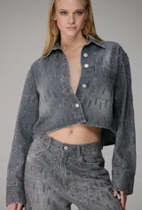 Pantalón de jean wide leg de tiro alto color gris, con diseño de silueta amplia y detalles de apliques brillantes distribuidos por toda la prenda.