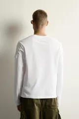 Camiseta de manga larga con cuello redondo y corte relajado. Presenta un pequeño bolsillo tipo plastrón con solapa en la manga izquierda.