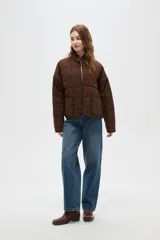 Campera acolchada de algodón con estampado animal print de leopardo en tonos marrones. Presenta cuello alto, cierre frontal, mangas largas y dos bolsillos frontales con ribetes oscuros.