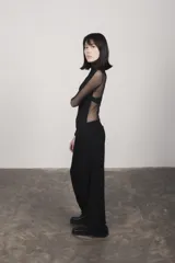 Camiseta negra de cuello alto y mangas largas con paneles de tul transparente en mangas y espalda.