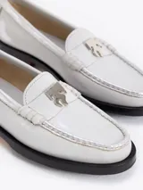 Mocasín de cuero vacuno con efecto gastado en tonos grises y negros. Presenta un aplique metálico con el logo Fire en la vincha y suela grabada con el nombre de la colaboración.