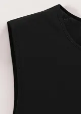 Top negro de algodón con cuello redondo y mangas cortas, con fucsia y detalle de lazo integrado para atar en la cintura.
