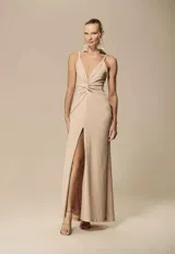 Vestido largo dorado con brillo, escote en V profundo, tirantes finos, detalle de nudo drapeado en el frente y tajo en la pierna.